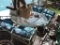 Glass top patio table with 4 chairs in rough condition.