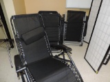 Five black portable lounge chairs.