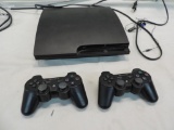 PlayStation 3 with two remotes.